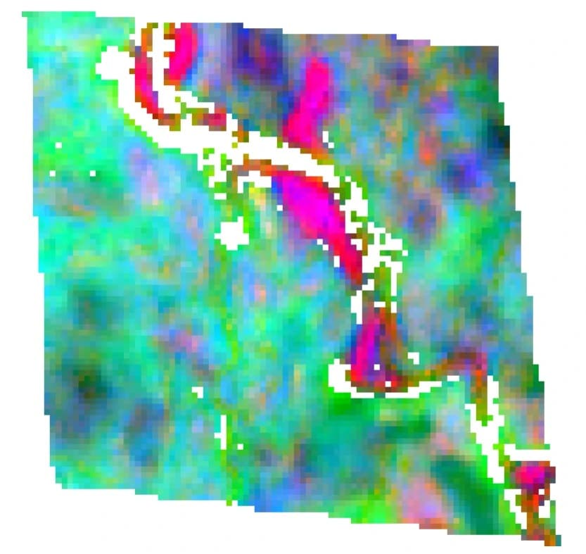Three-channel alteration composite of the same claim area, with magenta and red zones marking iron oxide and ferrous mineral signal