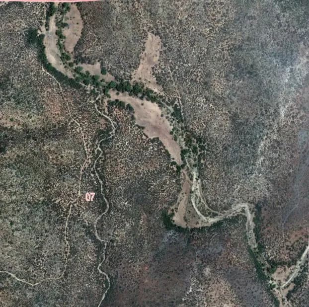 Aerial basemap of a mining claim showing drainages, roads, and claim boundary